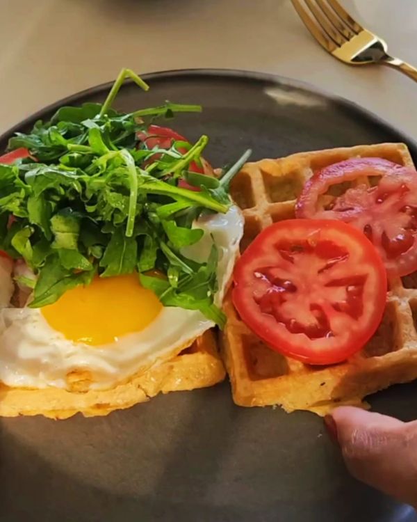 Step 3.1: Top your potato waffle with a fried egg, fresh tomato slices, avocado, and a dollop of fresh cream