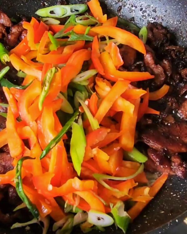 Step 5.1: Add the spring onions and red pepper strips, and stir-fry for another 1-2 minutes until the vegetables are just tender