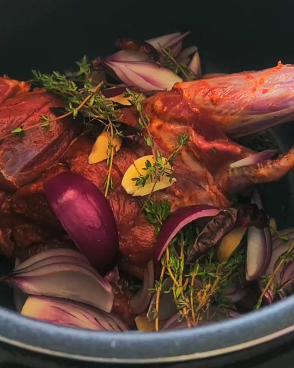 Step 4.1: Add the chopped tomatoes to the pot, then add the chunks of the broiled goat leg on top
