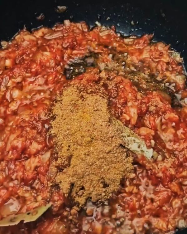 Step 4.1: Stir in grated tomatoes and tomato paste, followed by cumin, coriander, turmeric, and cayenne powder