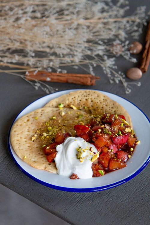 Step 2.1: Serve the spiced apples warm on top of the pancakes, garnished with crushed pistachios and sour cream if desired