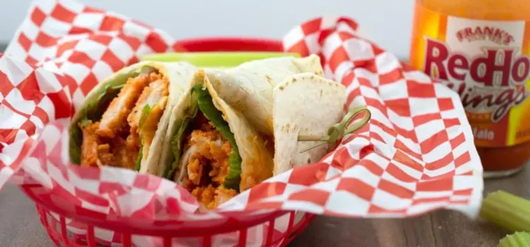 Step 1.1: Place a tortilla on a flat work surface and top with a piece of romaine lettuce, half of the chicken, half of the shredded cheese, and half of the ranch dressing