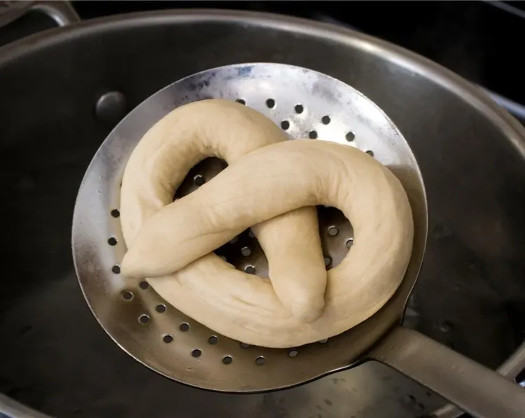 Step 2.1: Transfer the pretzel to the parchment-lined baking sheet and cover with a damp tea towel while you work on the remaining pretzels