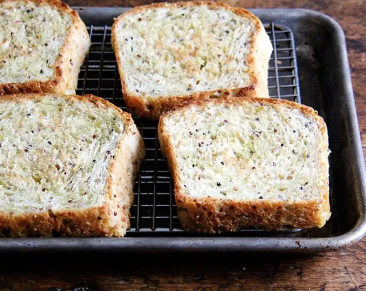Step 3.1: Remove pan from oven, flip slices of bread over, drizzle with more oil, and return pan to the oven for another 2 minutes, or until bread is golden