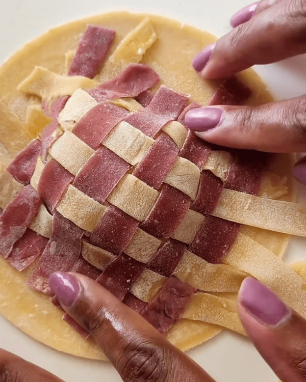 Step 5.1: Carefully lay the lattice over the egg yolk and filling, then seal the edges by pressing them together gently