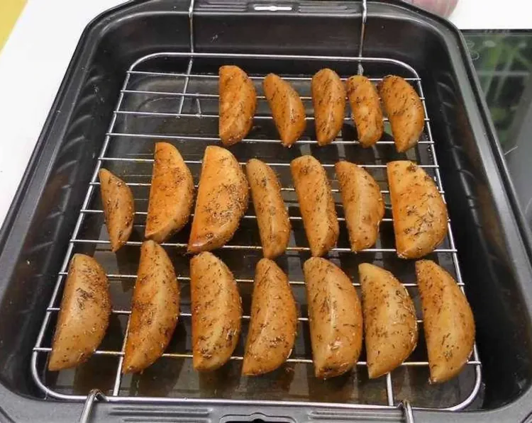 Step 1.1: Once the wedges are covered in oil and spices, remove them and place on a baking rack with a tray