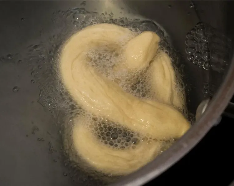 Step 2.1: Place the pretzels, 2 at a time, into the boiling water for 30 seconds, splashing the tops with a spoon