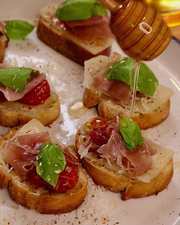 Tomato Garlic Confit Baguette with Asiago, Prosciutto, Basil, and Honey recipe
