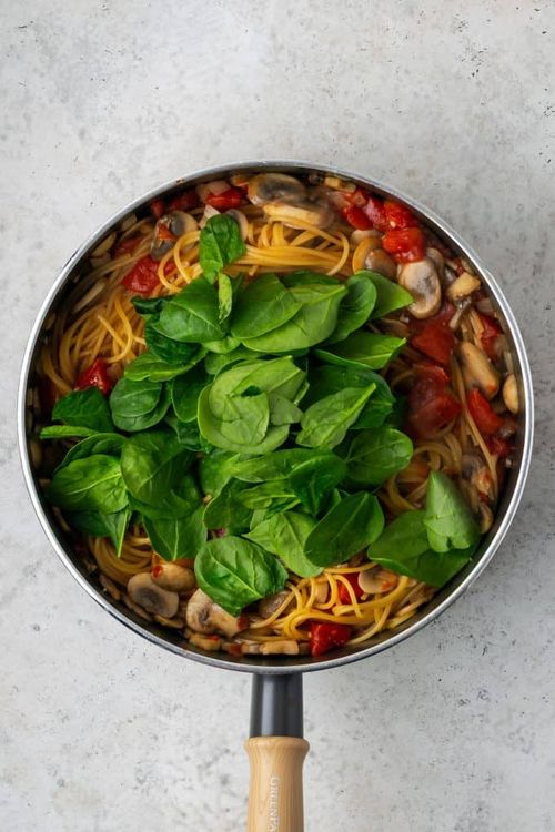 Step 1.1: Remove lid and add fresh spinach, a couple of handfuls at a time, stirring to mix and wilt the spinach