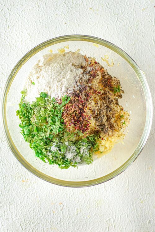 Step 1.1: Stir in the all-purpose flour, salt, pepper, garlic powder, onion powder, chili flakes, oregano, and chopped parsley into the potatoes and mix to create a dough