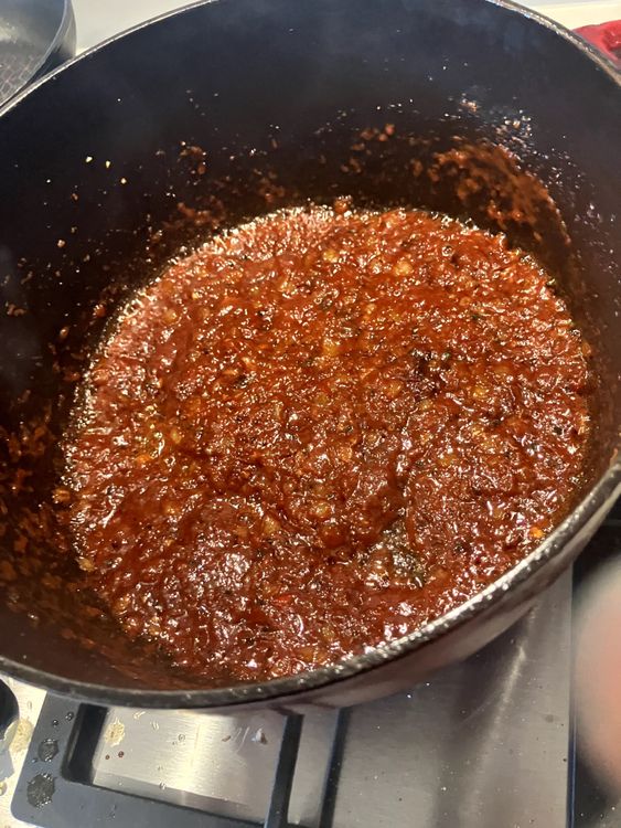 Step 2.3: Add the flour, mixing it through to coat everything, and then pour in the red wine to deglaze the base of the pan