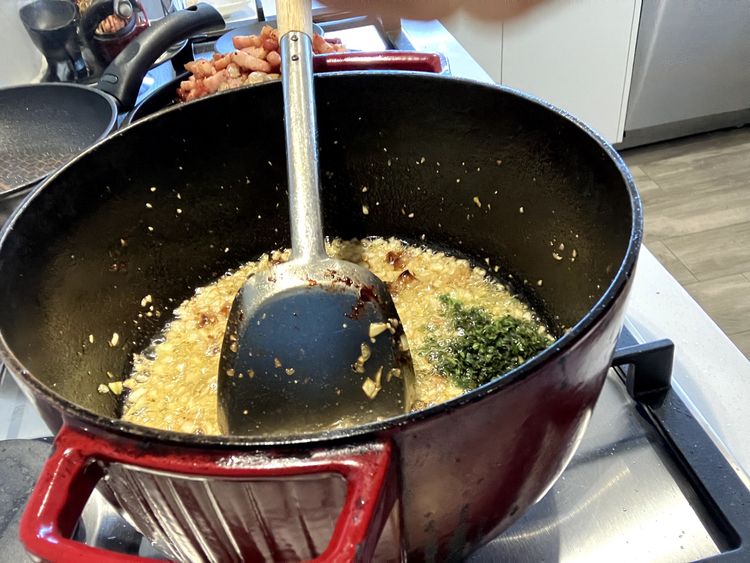 Step 2.2: Add the chillies, basil, and oregano and cook for a further minute, ensuring everything is evenly distributed