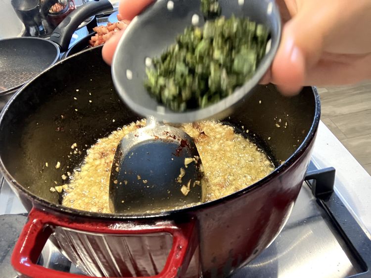 Step 2.1: Add the chillies, basil, and oregano and cook for a further minute, ensuring everything is evenly distributed