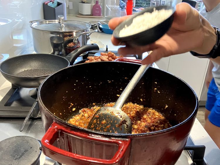 Step 2.1: Add the flour, mixing it through to coat everything, and then pour in the red wine to deglaze the base of the pan