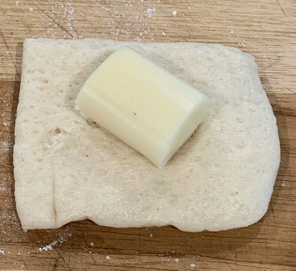 Step 1.1: Place a chunk of mozzarella on each piece of dough