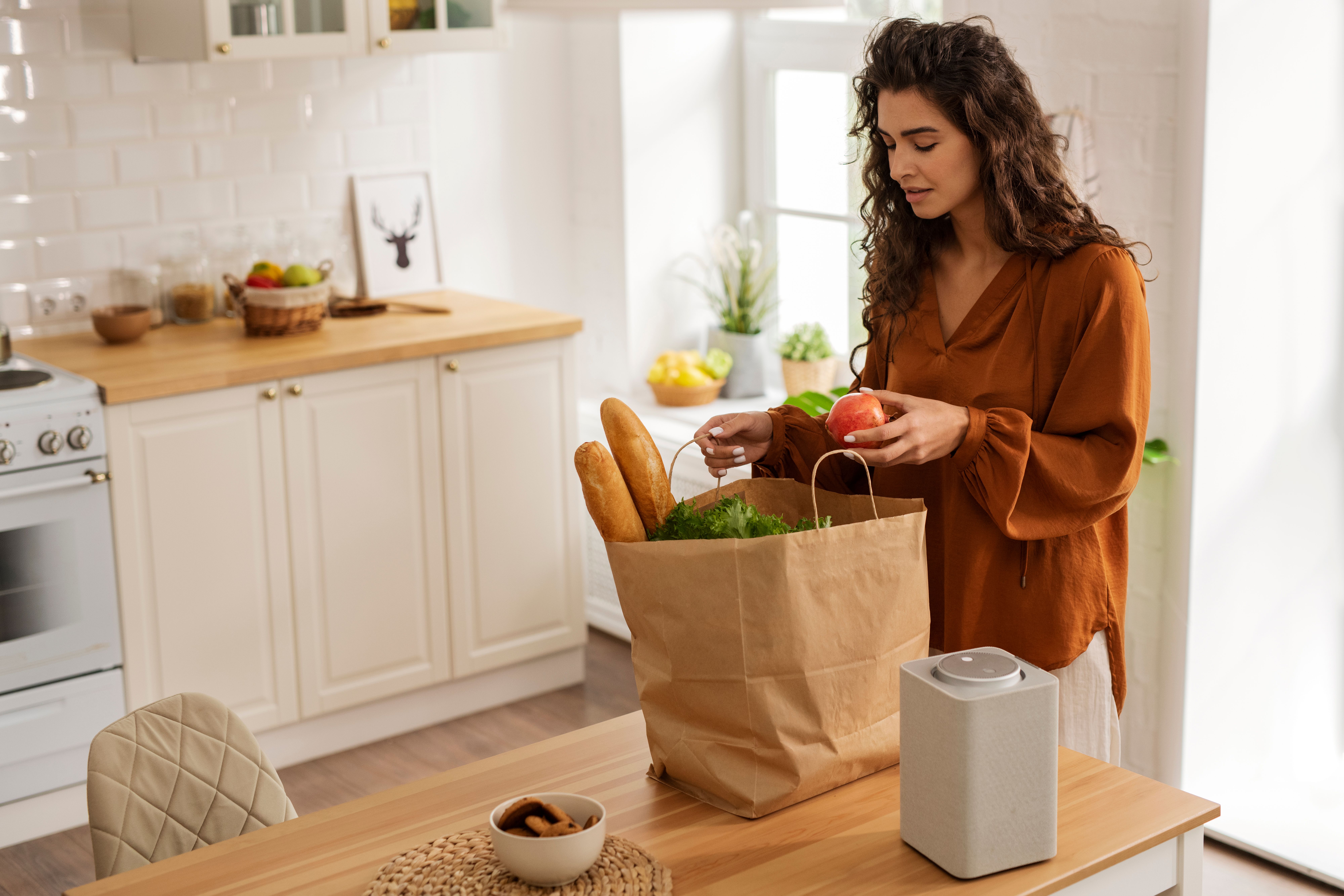 Side view of a woman holding groceries in reusable bags for a zero-waste kitchen approach